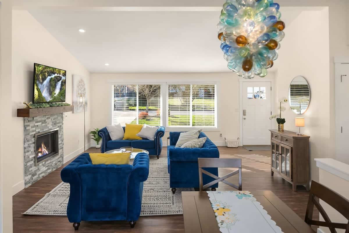 Living room with blue seating, fireplace and dining area